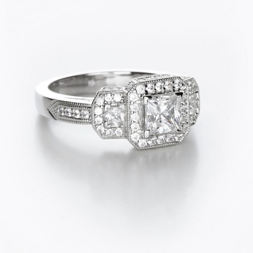 A contemporary diamond ring with a princess cut center stone and pave accents.