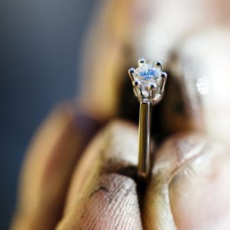 Ring held by jeweler after polishing it