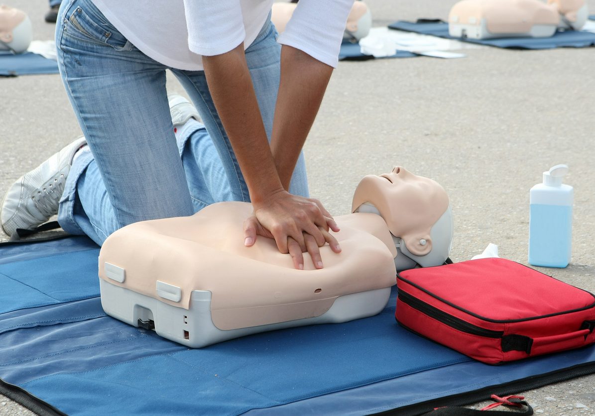 Female instructor showing CPR on training doll